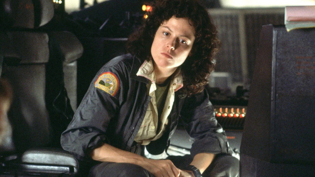 Sigourney Weaver as Ellen Ripley in Alien, leaning forward in a chair with a thoughtful look on her face