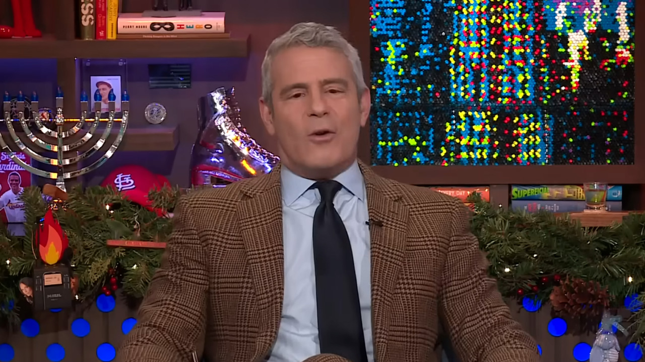 Andy Cohen, in a tan suit and black tie.