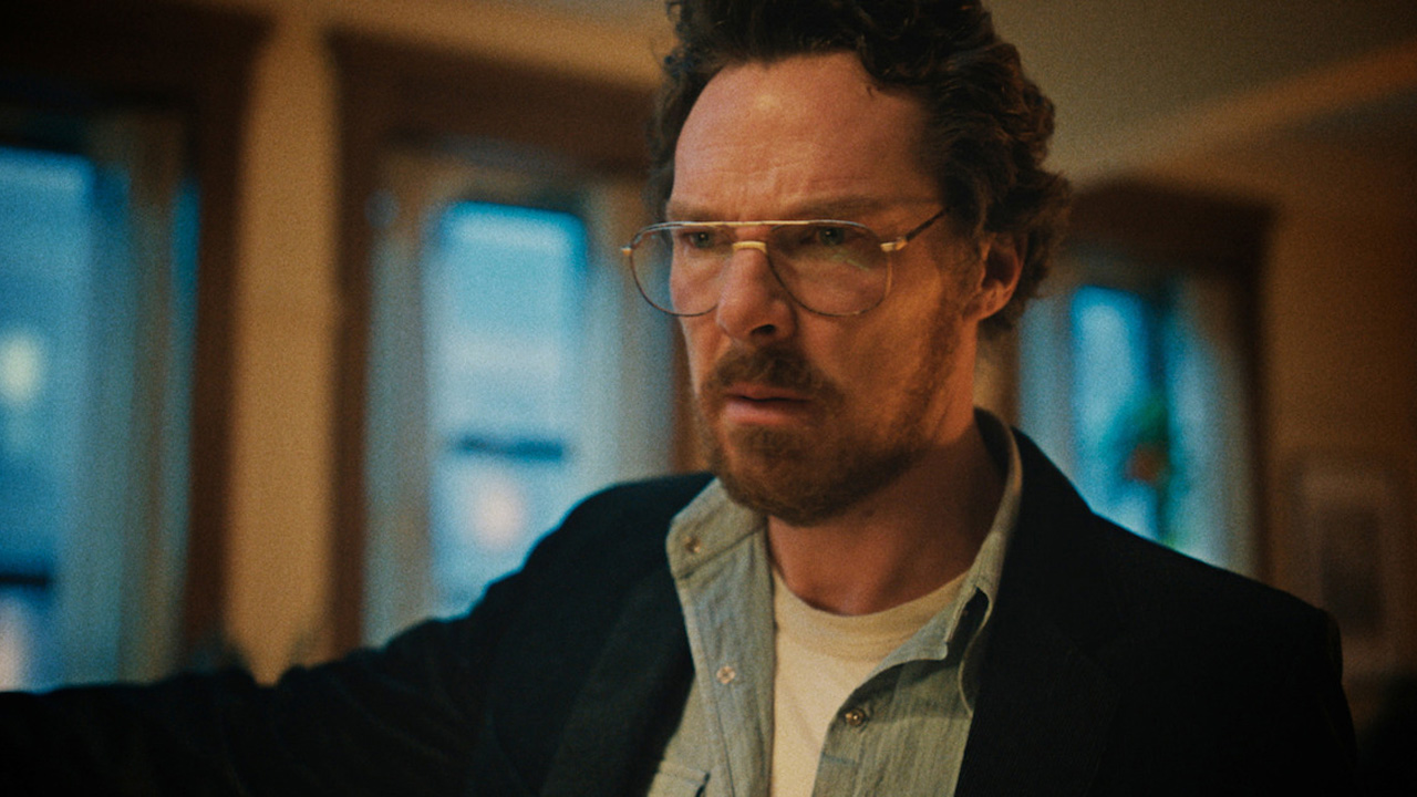 Benedict Cumberbatch as Vincent in Eric, a man with beard and glasses in a blue shirt and black jacket.