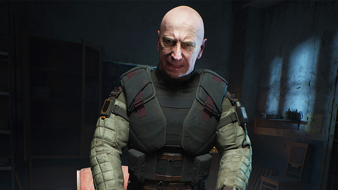 Stalker 2, a bald-headed man wearing protective armour, in a darkened room.