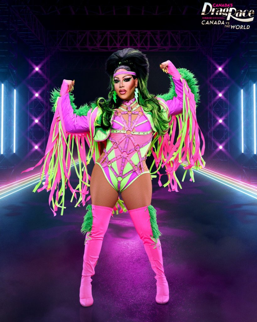 Image of Alexis Mateo posing in a neon pink and  green leotard with straps and tassels on a runway