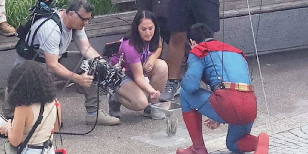 David Corenswet kneeling down in front of a squirrel on the set of James Gunn's Superman movie.