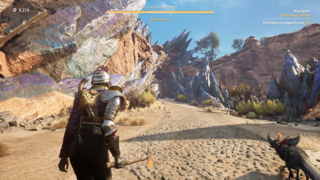 The player walks a sandy trail, with fluorite-hued crystals jutting from the cliffs on either side of them, a black fox-like creatureat their side