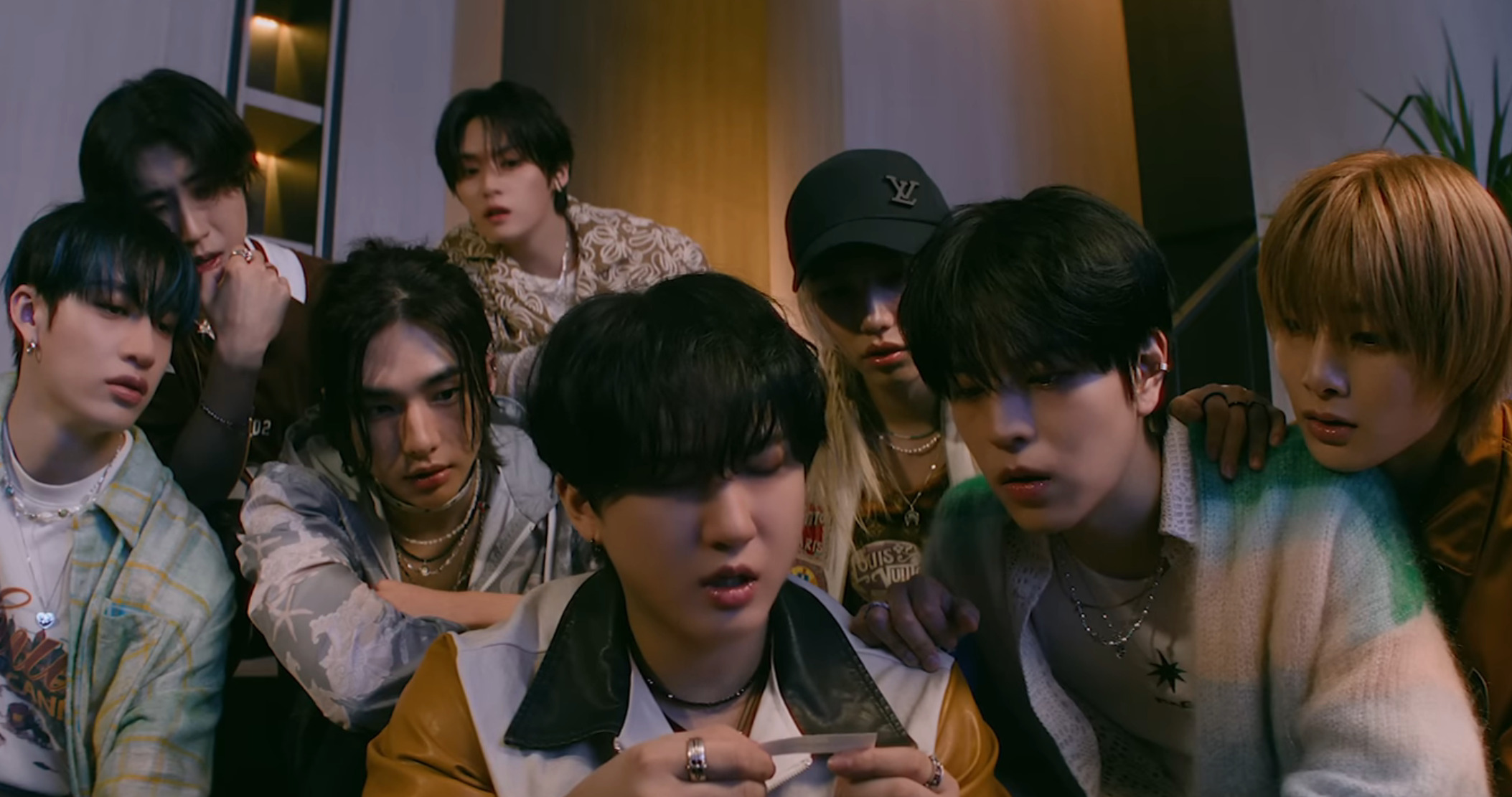 Stray Kids checks a phone message about their album release