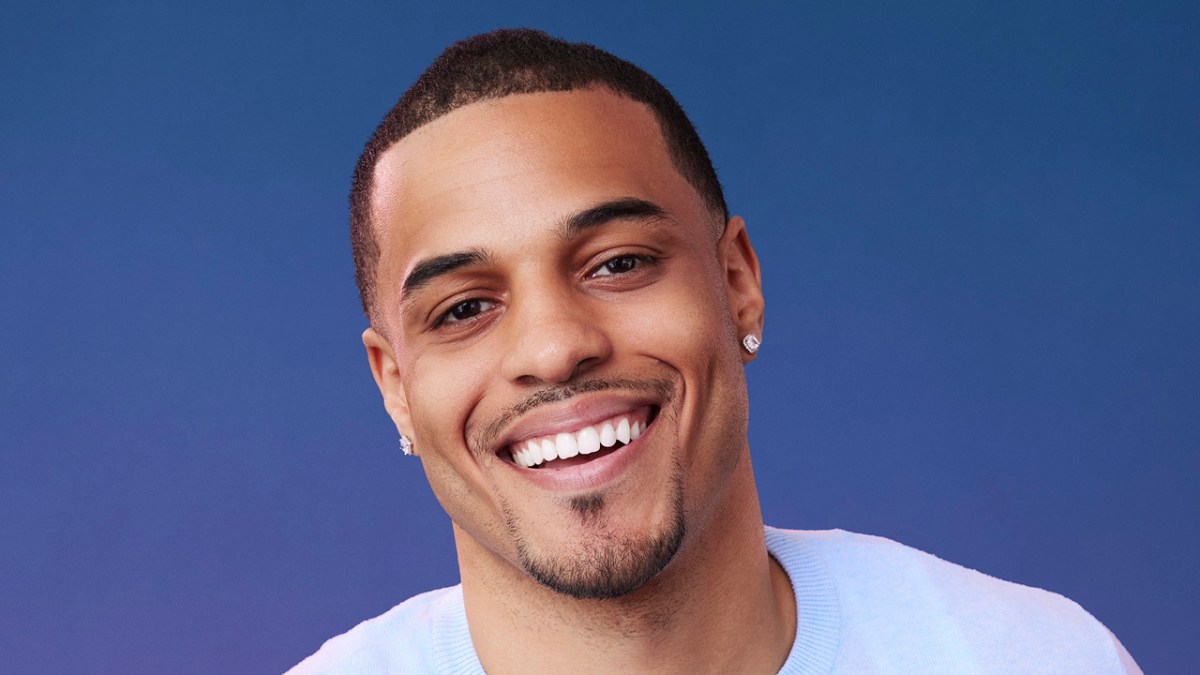 The Bachelor, Season 29 lead Grant Ellis smiling at the camera in front of a blue background.