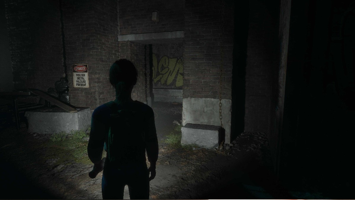 The player character stands outside of a brick building with an opening and a sign that warns about molten metal hazards on the adjacent wall in The Casting of Frank Stone