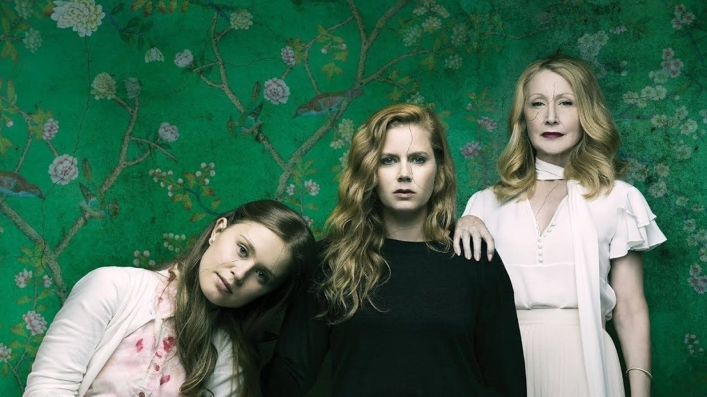 Key art for HBO's Sharp Objects, featuring three women standing in a room with green wallpaper