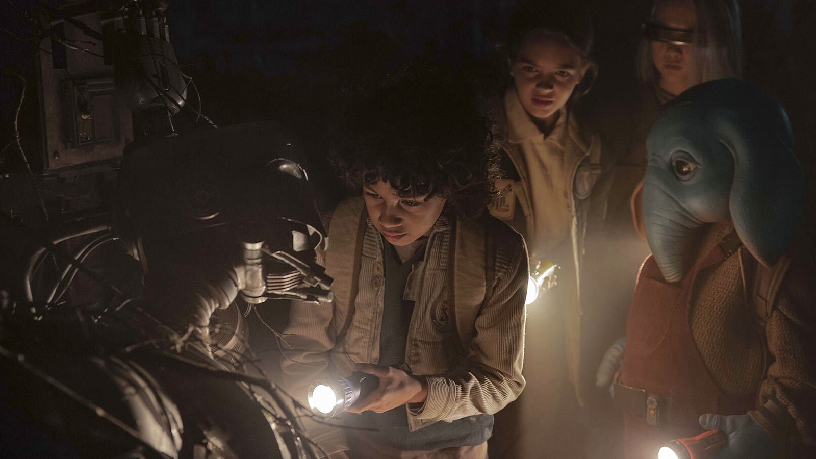 Wim, Fern, KB, and Neel pointing flashlights at SM 33 in Star Wars: Skeleton Crew