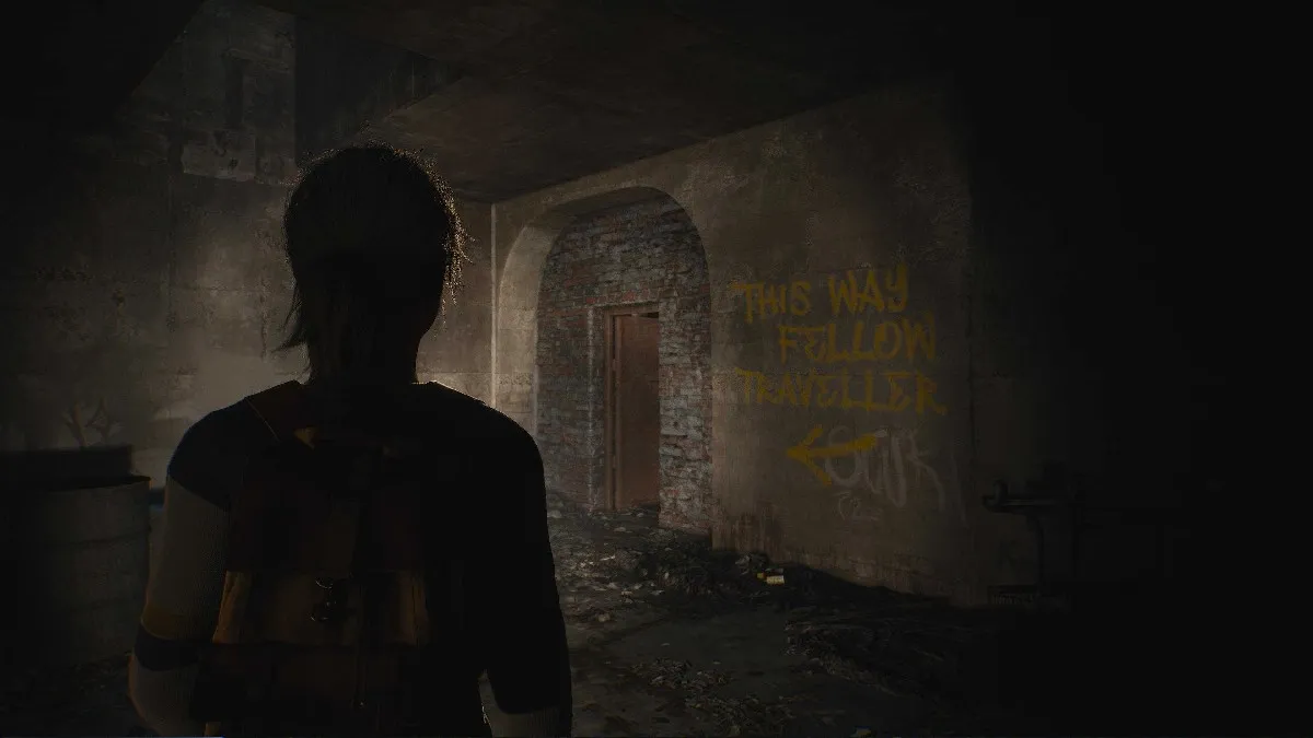 Image of Chris in an underground tunnel, looking at a door with graffiti reading "This way fellow traveller" on the wall in The Casting of Frank Stone