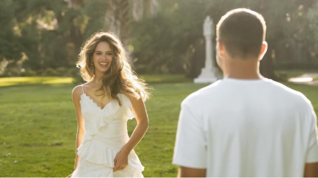 The Bachelor Joey and Kelsey engagement photos from Instagram, with Kelsey looking at Joey in a white dress with the sun in her hair