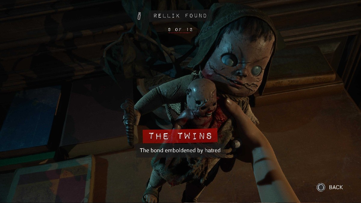 The Twins Rellik in hand, which looks like a porcelain doll