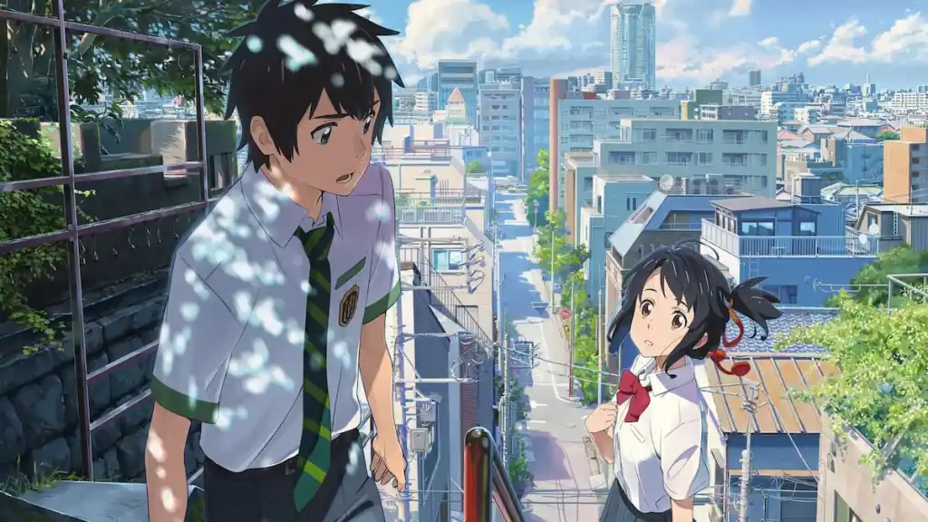 A boy and girl lock eyes as they climb stairs that overlook a city in anime movie Your Name