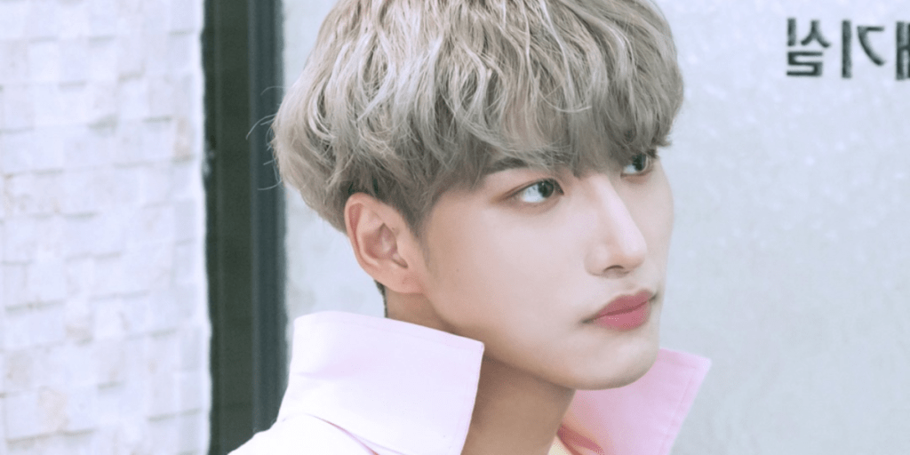 Seonghwa stares off screen with a serious look on his face