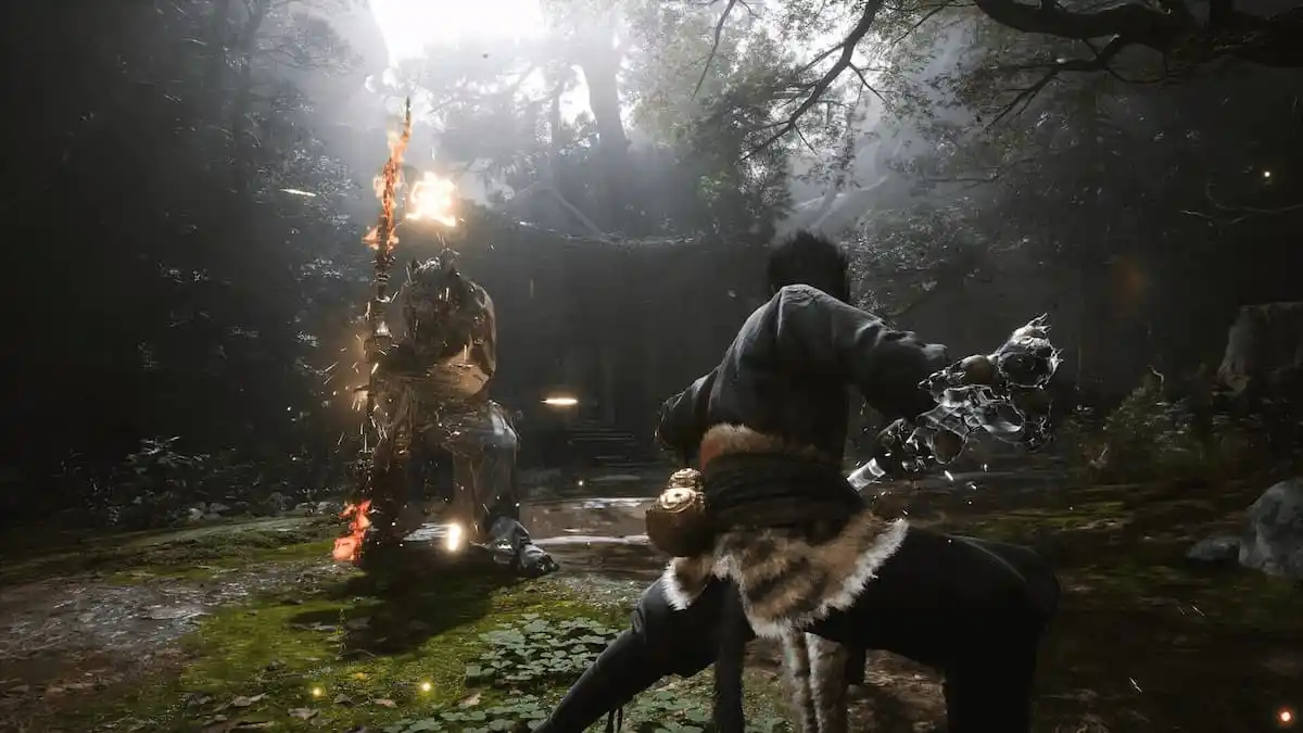 Wukong sits low in a fighting stance while a boss prepares to strike him with a flaming staff in Black Myth: Wukong