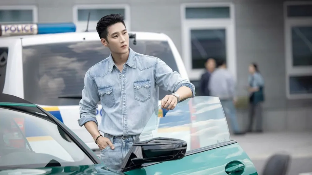 I-soo stands by a police car