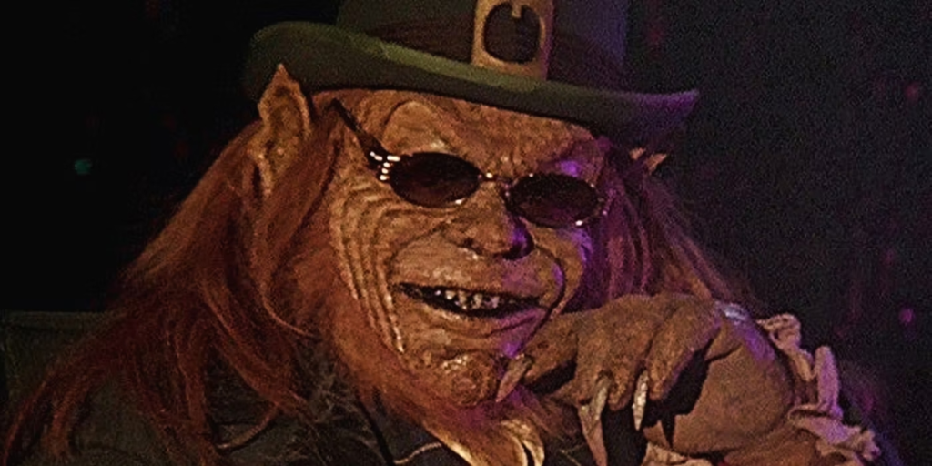 The leprechaun smiles wearing sunglasses as part of an article about the best horror movies that are so bad they're good.