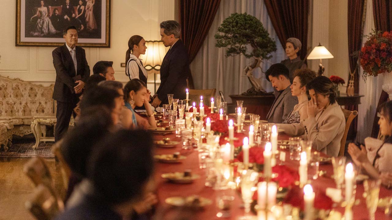 Netflix's Master of the House, several people at a long dining table, while two stand at the head of the table, a man and a woman.