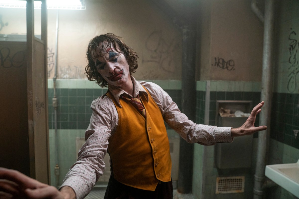 Joaquin Phoenix as the joker dancing in a men's bathroom in Joker