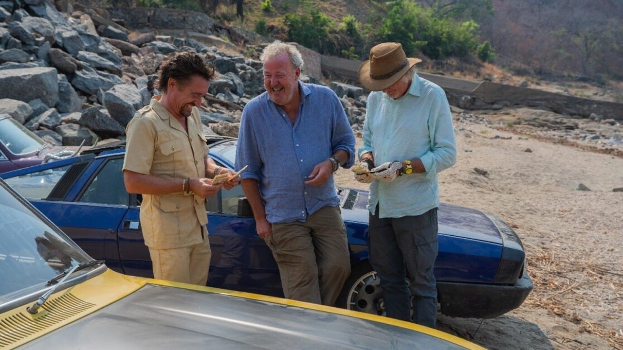 The Grand Tour: One For the Road, Jeremy Clarkson, RIchard Hammond and James May standing by a car.