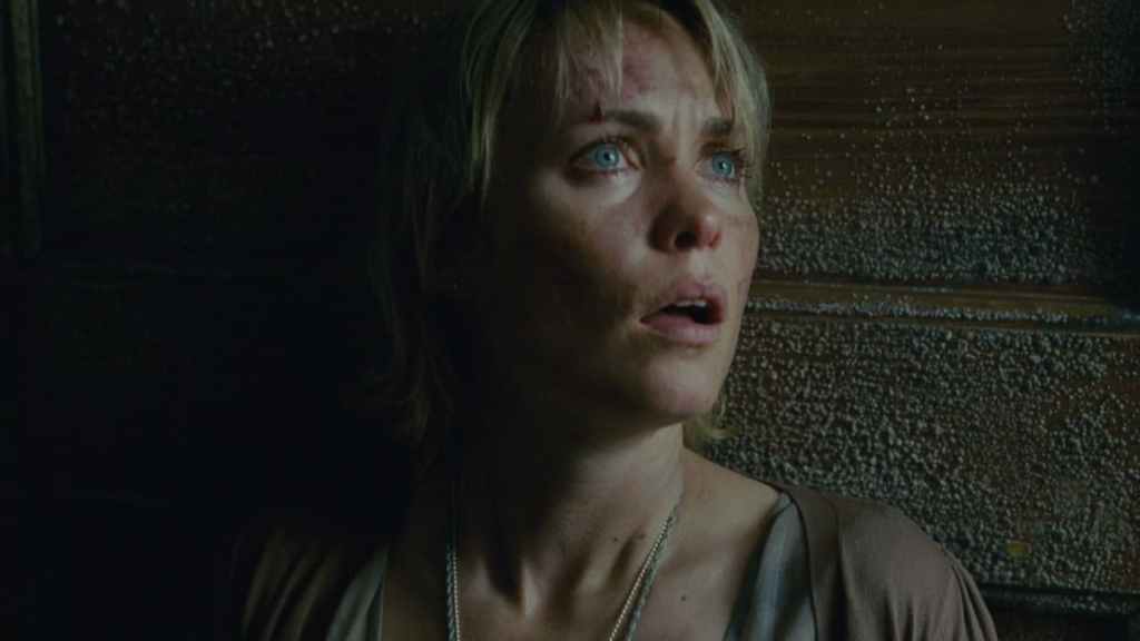 Silent Hill, the movie, with Sharon leaning against a door, panicked. 