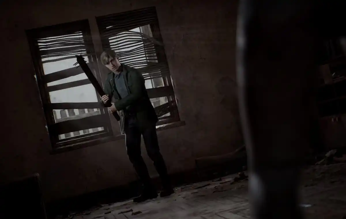 a still of james holding up a weapon in silent hill 2