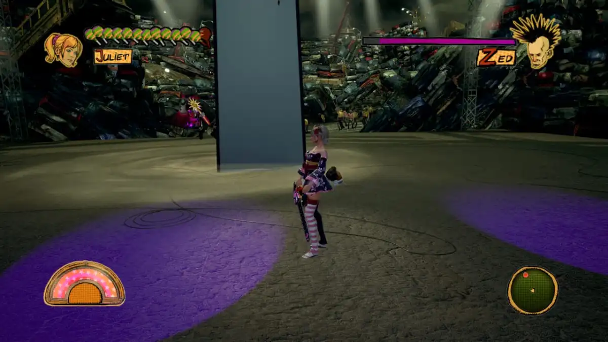 Zed floats in the air on stage in Chainsaw Lollipop RePop, with a wall of cars in the background 