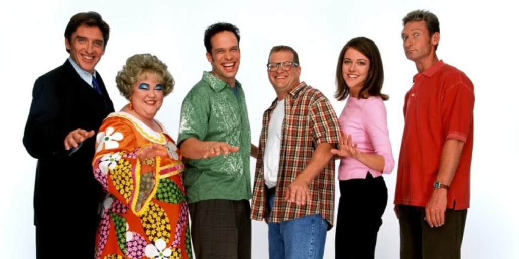 The main cast of The Drew Carey Show in front of a white background as part of an article about '90s sitcoms.