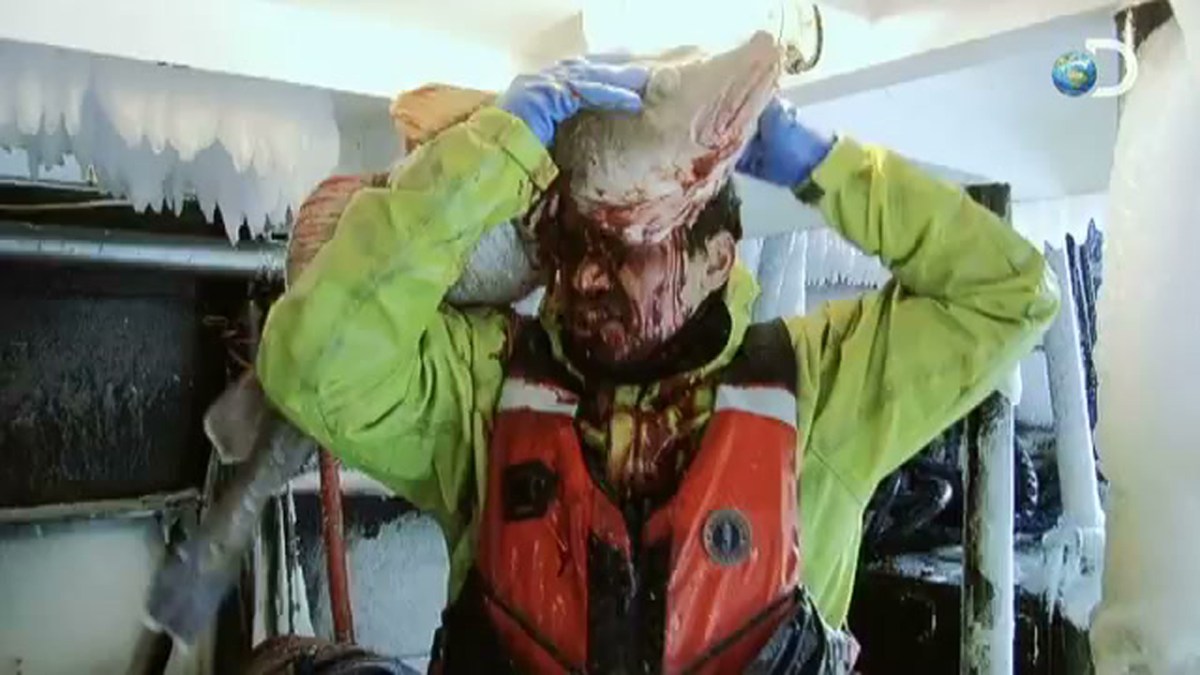 Deadliest Catch, Freddy Maugatai smearing a fish over his head and face. 