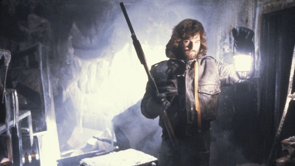 MacReady holds up a rifle and lantern