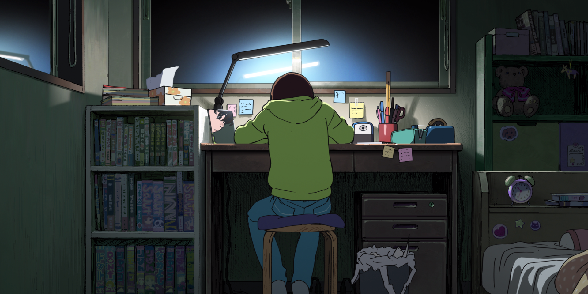 Fujino sits at a desk making manga in Look Back