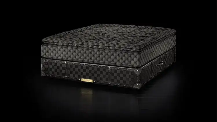 A black, chequered mattress on a base as part of an article about The Most Expensive (and Ridiculous) Celebrity Purchases Over $100,000