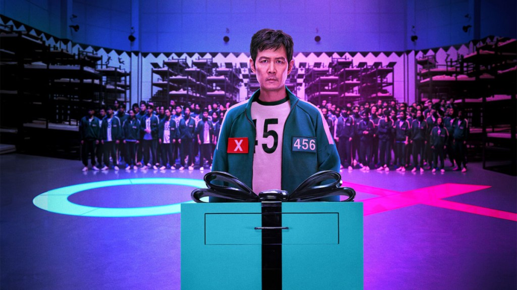 Squid Game, a man in a blue tracksuit standing in front of a podium.